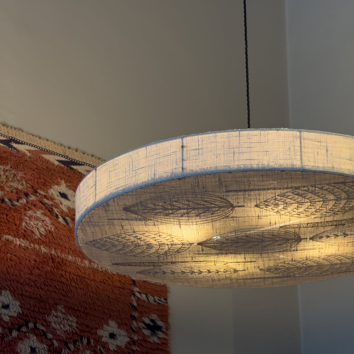 Sigmar London. Designed in the 1970s, the lamp emits a soft, diffused light through delicate stitched patterns, blending textile craftsmanship with functional lighting, from Sweden.