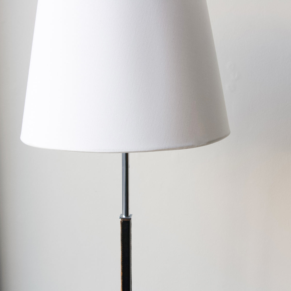 A vintage 1960s full-length floor lamp by Philips Netherlands, featuring a sleek steel frame complemented by leather accents. This mid-century modern design combines industrial materials with refined craftsmanship, offering both style and functionality.