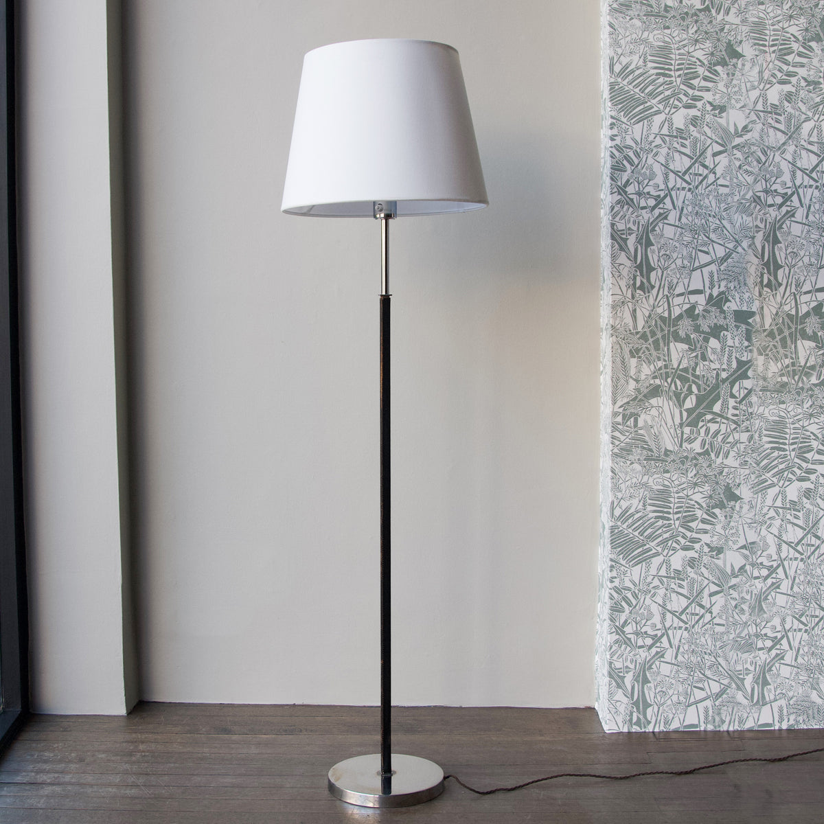 A vintage 1960s full-length floor lamp by Philips Netherlands, featuring a sleek steel frame complemented by leather accents. This mid-century modern design combines industrial materials with refined craftsmanship, offering both style and functionality.