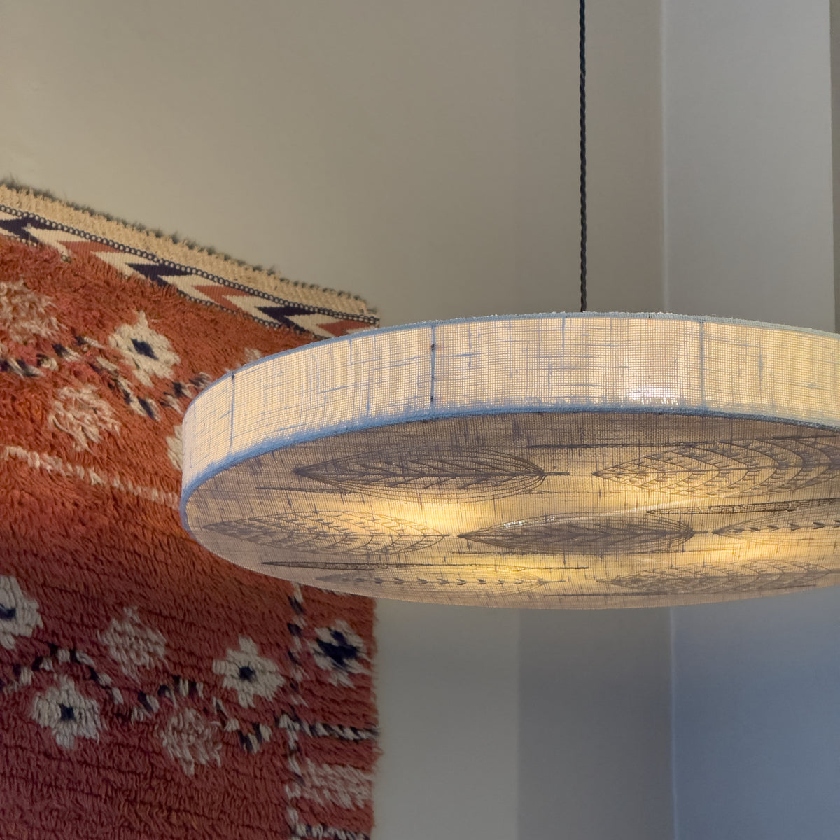 Sigmar London. Designed in the 1970s, the lamp emits a soft, diffused light through delicate stitched patterns, blending textile craftsmanship with functional lighting, from Sweden.