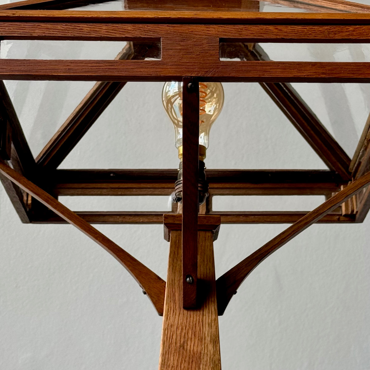 Wooden lamp with a clear glass shade against a white background
