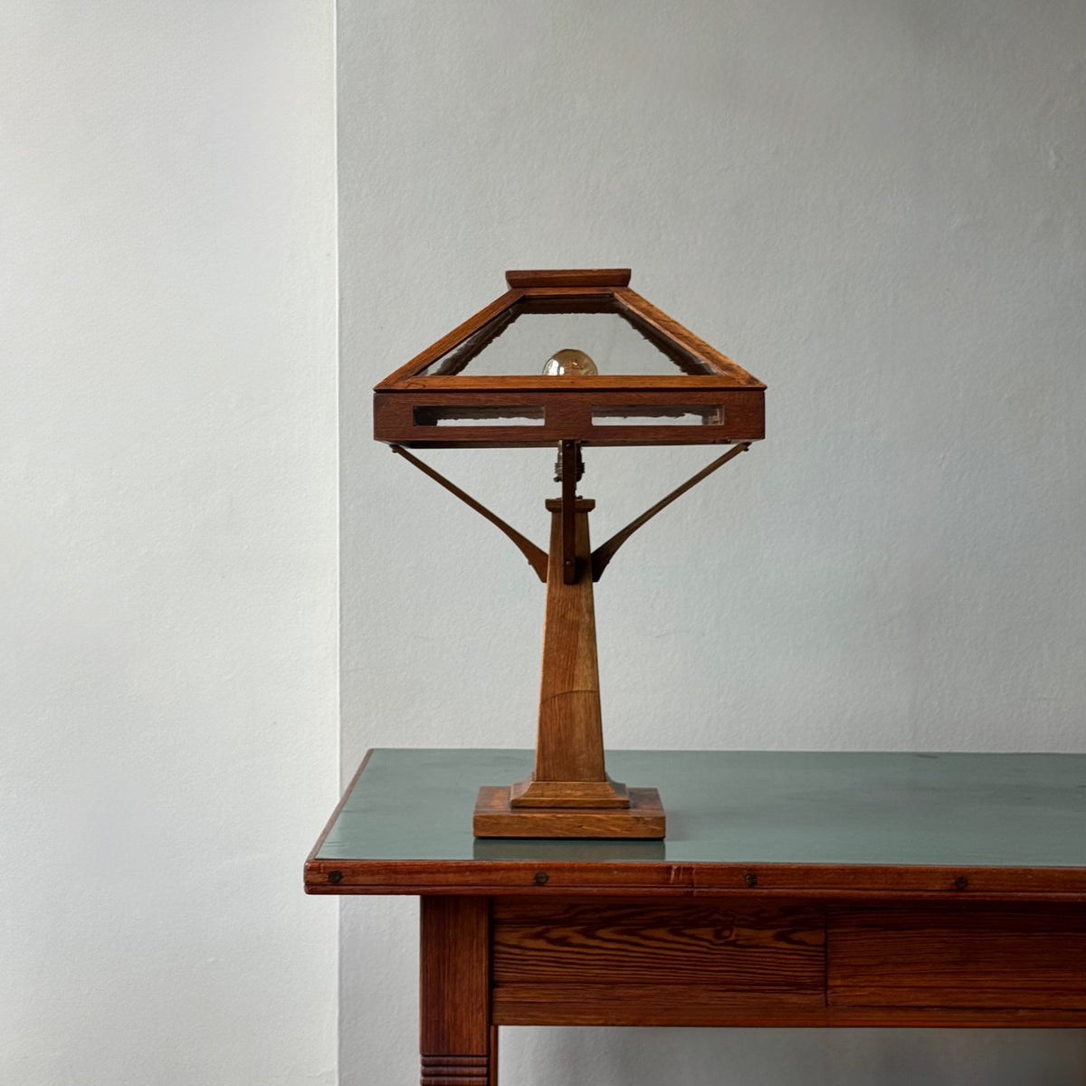 Wooden table lamp on a wooden desk with a plain background