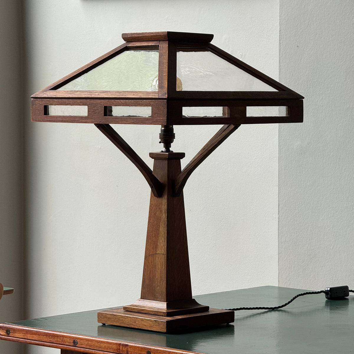 Wooden table lamp with glass shade on a gray surface