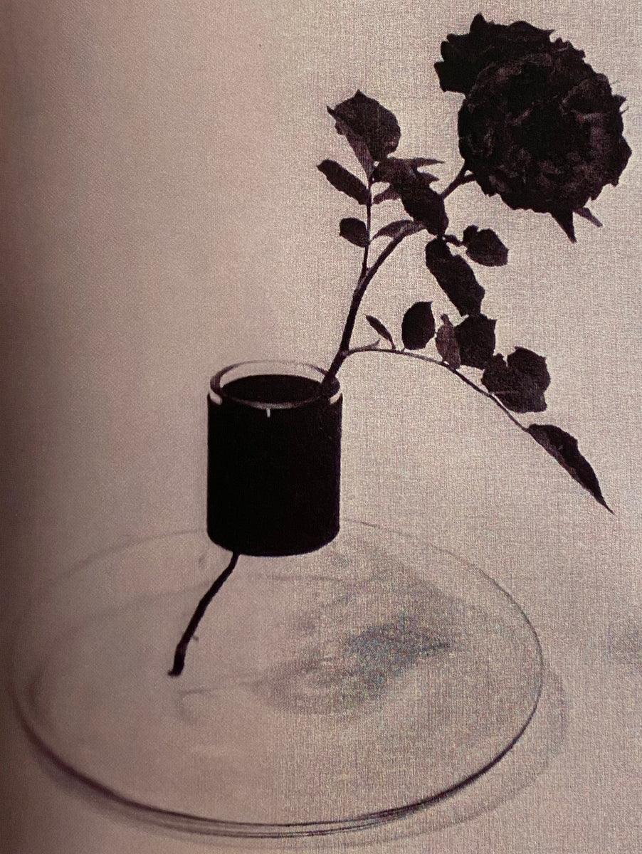 A archival image of a #4748 vase designed by Carl Auböck II during the 1950s. The vase is shown with a single rose against a white background.
