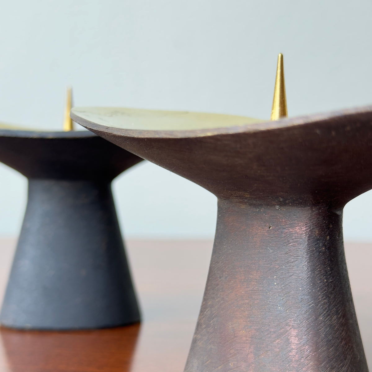 A pair of patinated brass candlesticks by Carl Auböck, crafted in the Werkstätte Auböck workshop, 1950. These candlesticks reflect Bauhaus influences and mid-century Austrian craftsmanship.
