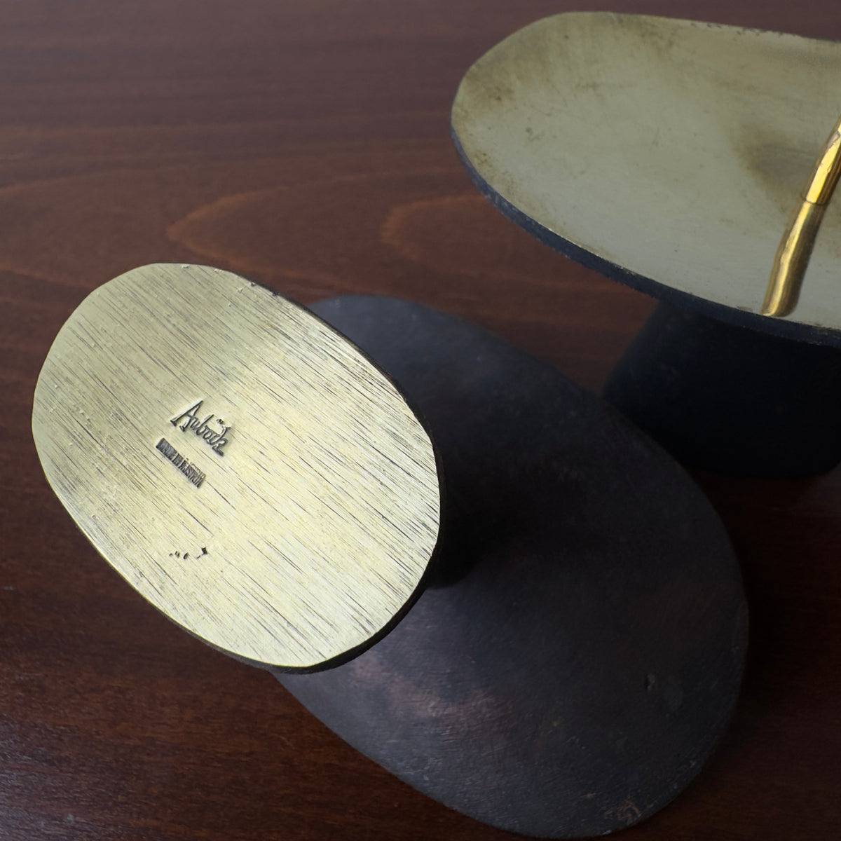A pair of patinated brass candlesticks by Carl Auböck, crafted in the Werkstätte Auböck workshop, 1950. These candlesticks reflect Bauhaus influences and mid-century Austrian craftsmanship.