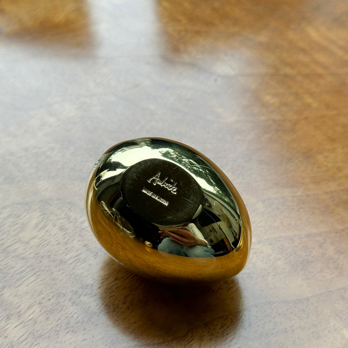 An egg-shaped paperweight designed by Carl Auböck II, made of solid cast brass in Vienna. This piece exemplifies modernist design with its smooth, minimalist form.