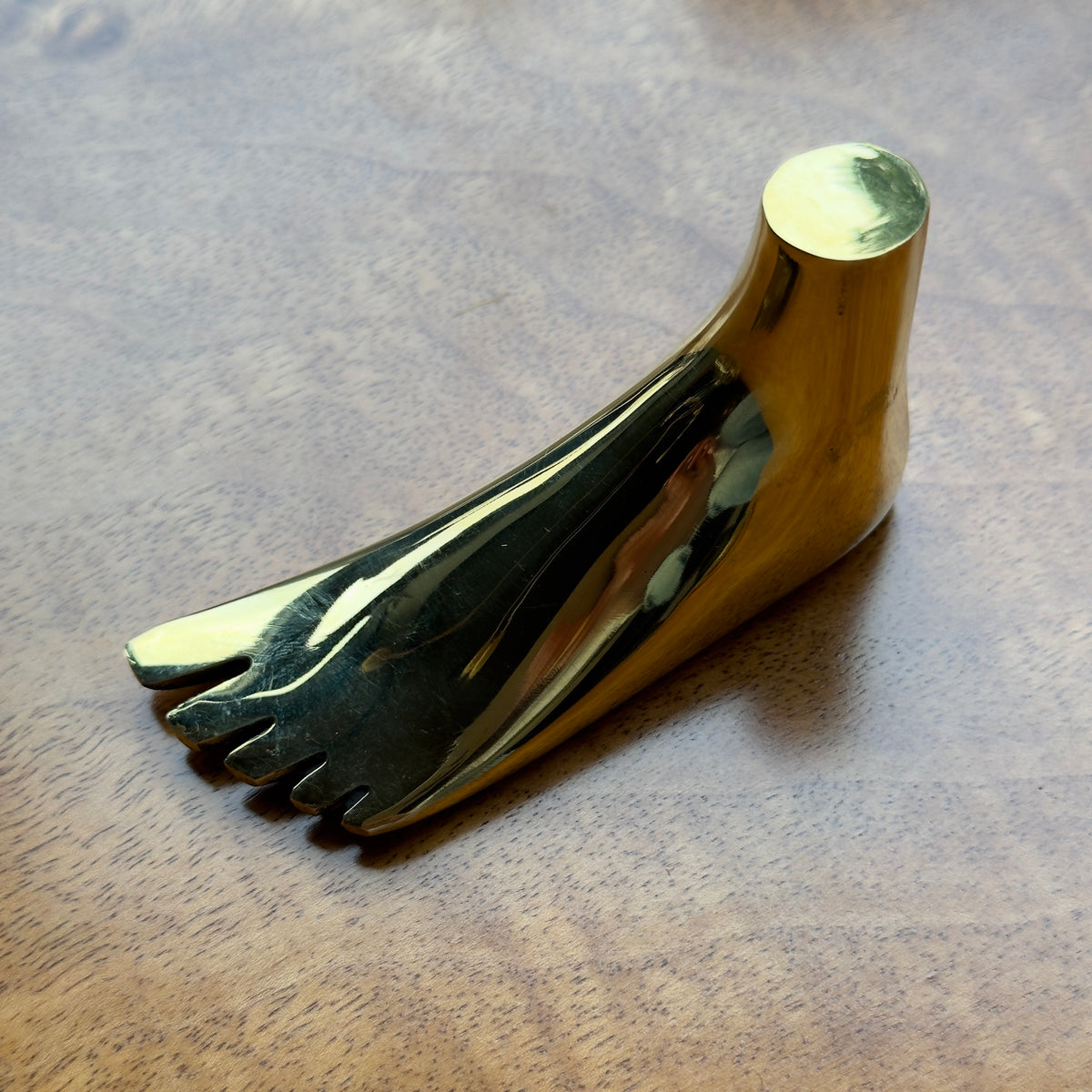 A foot-shaped paperweight designed by Carl Auböck II, made of cast brass in Vienna. This modernist piece showcases the distinctive craftsmanship and playful design typical of Auböck's work.