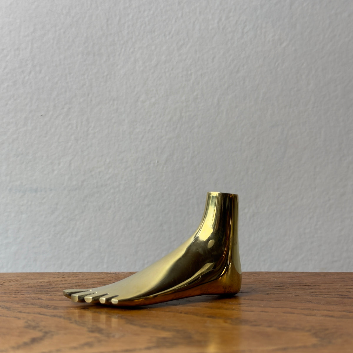A foot-shaped paperweight designed by Carl Auböck II, made of cast brass in Vienna. This modernist piece showcases the distinctive craftsmanship and playful design typical of Auböck's work.