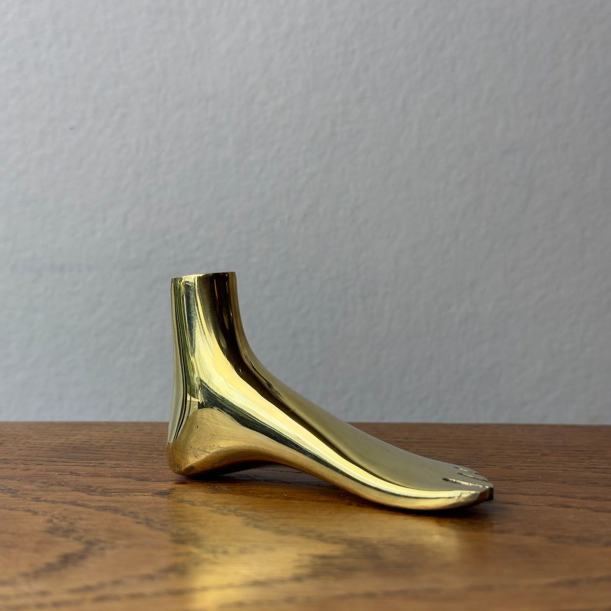 A foot-shaped paperweight designed by Carl Auböck II, made of cast brass in Vienna. This modernist piece showcases the distinctive craftsmanship and playful design typical of Auböck's work.