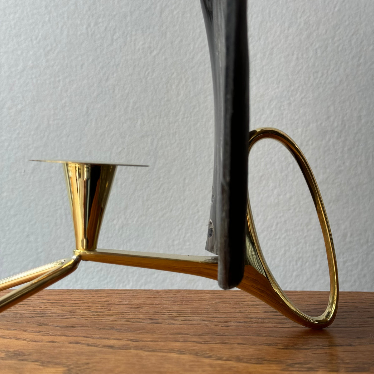 A cast brass horn candle holder and lantern sconce designed by Carl Auböck, made in Austria. This piece combines functionality with elegant, modernist design.