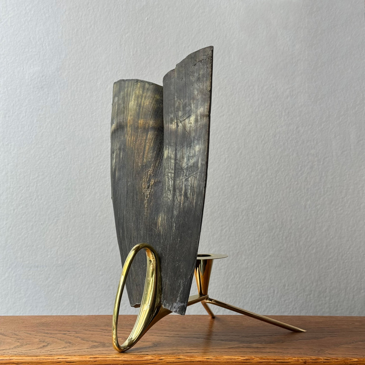 A cast brass horn candle holder and lantern sconce designed by Carl Auböck, made in Austria. This piece combines functionality with elegant, modernist design.