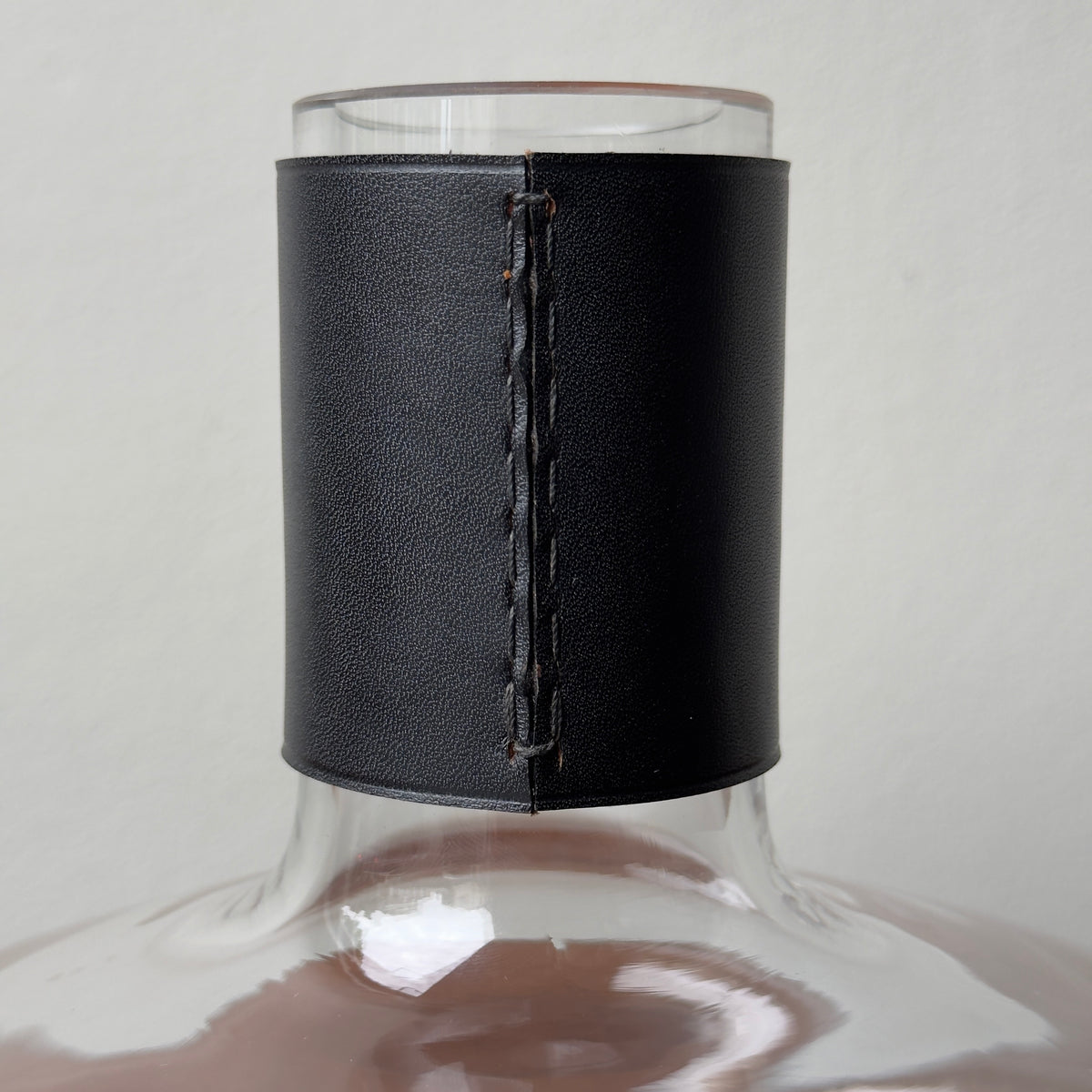 A vintage Carl Auböck vase with leather collar designed by Carl Auböck II. This vase is hand-blown and testament to the craftsmanship of this prestigious Austrian workshop.