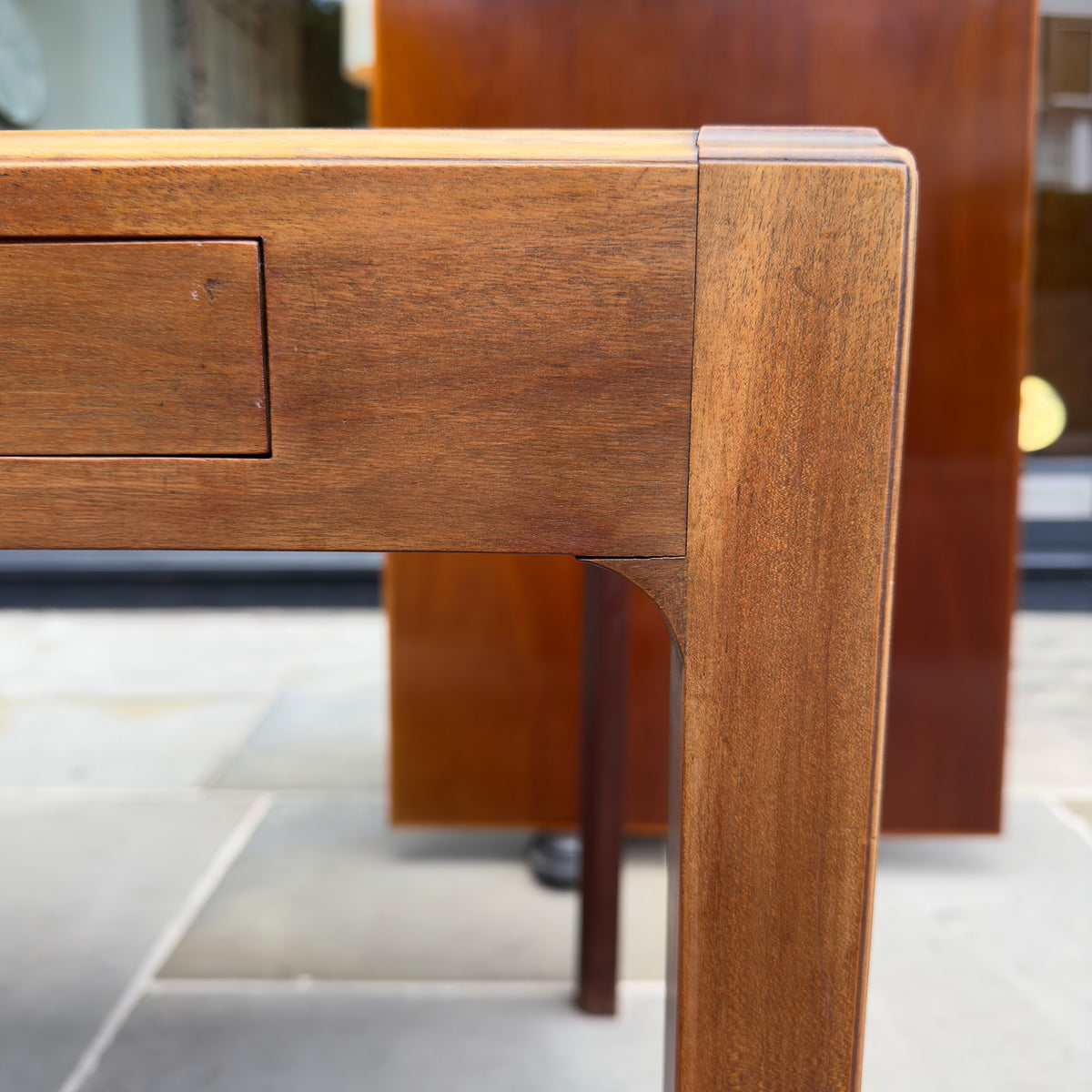 A 1950s Danish drafting table made of mahogany, featuring a reversible top, a drawer, and a central compartment. This piece combines functionality with classic mid-century design.