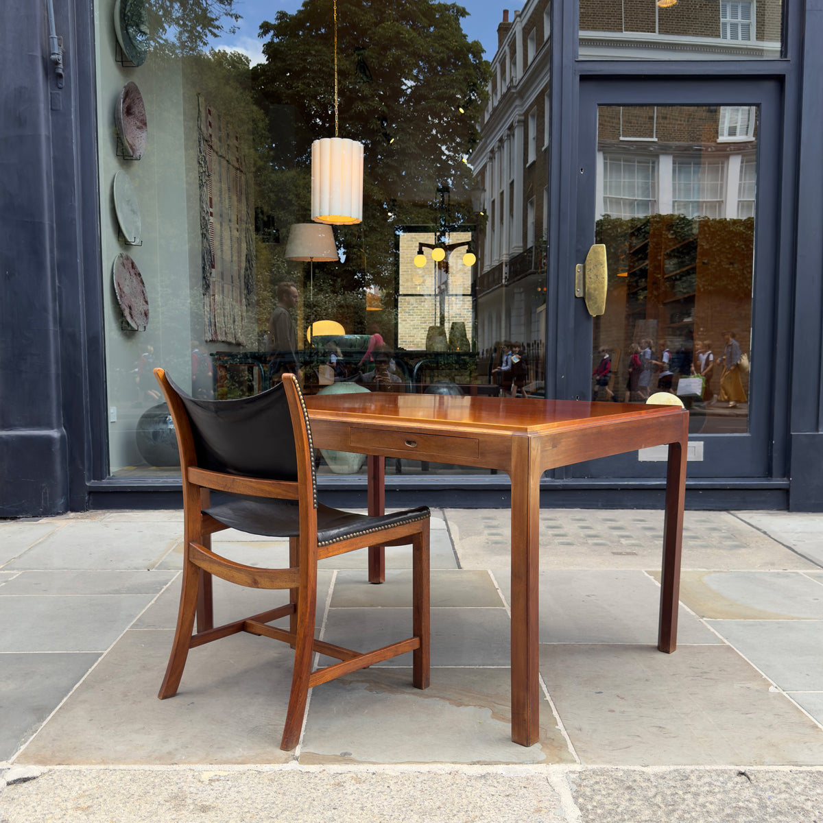 A 1950s Danish drafting table made of mahogany, featuring a reversible top, a drawer, and a central compartment. This piece combines functionality with classic mid-century design.