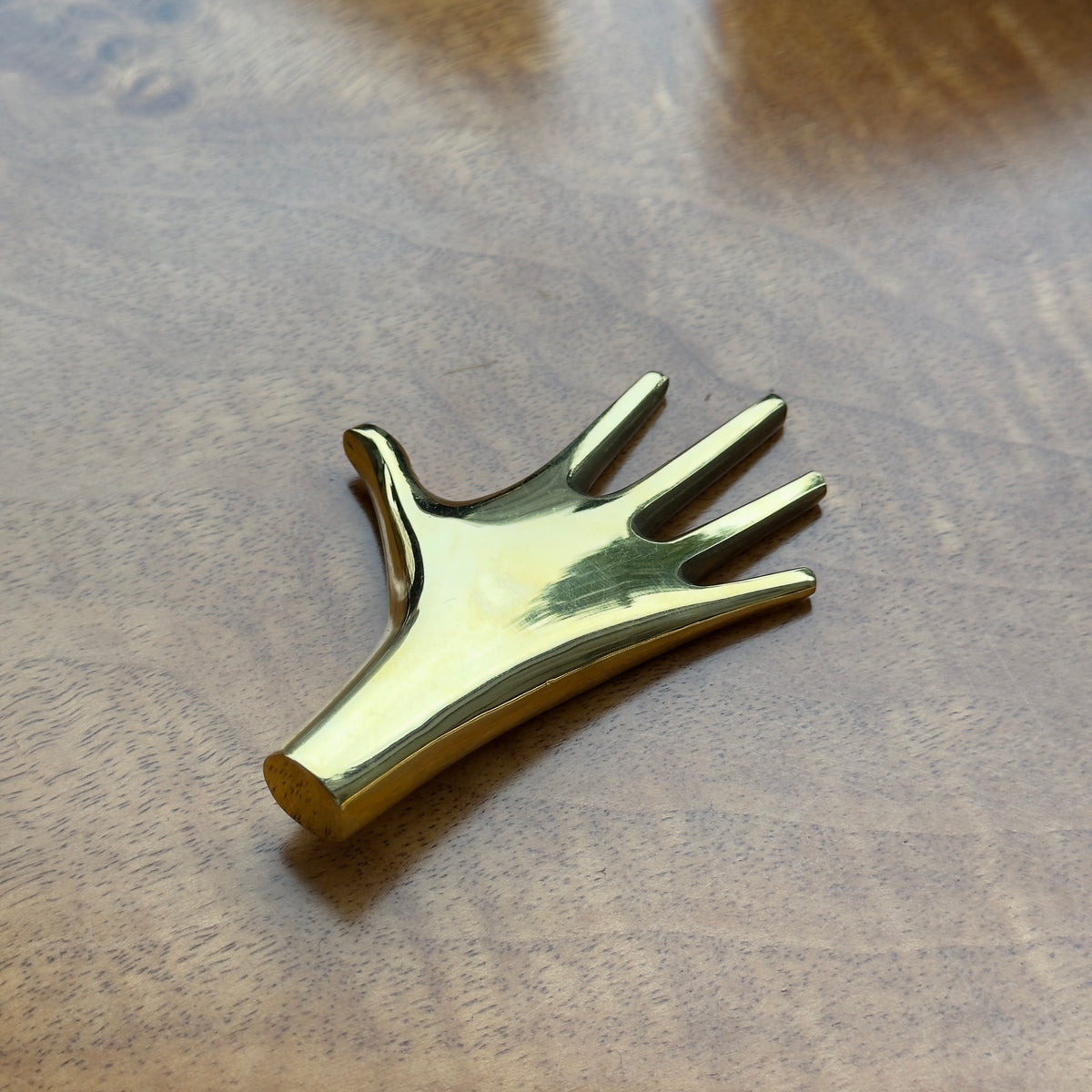 A hand-shaped paperweight designed by Carl Auböck II, made of cast brass in Vienna. This modernist piece showcases the distinctive craftsmanship and playful design typical of Auböck's work.