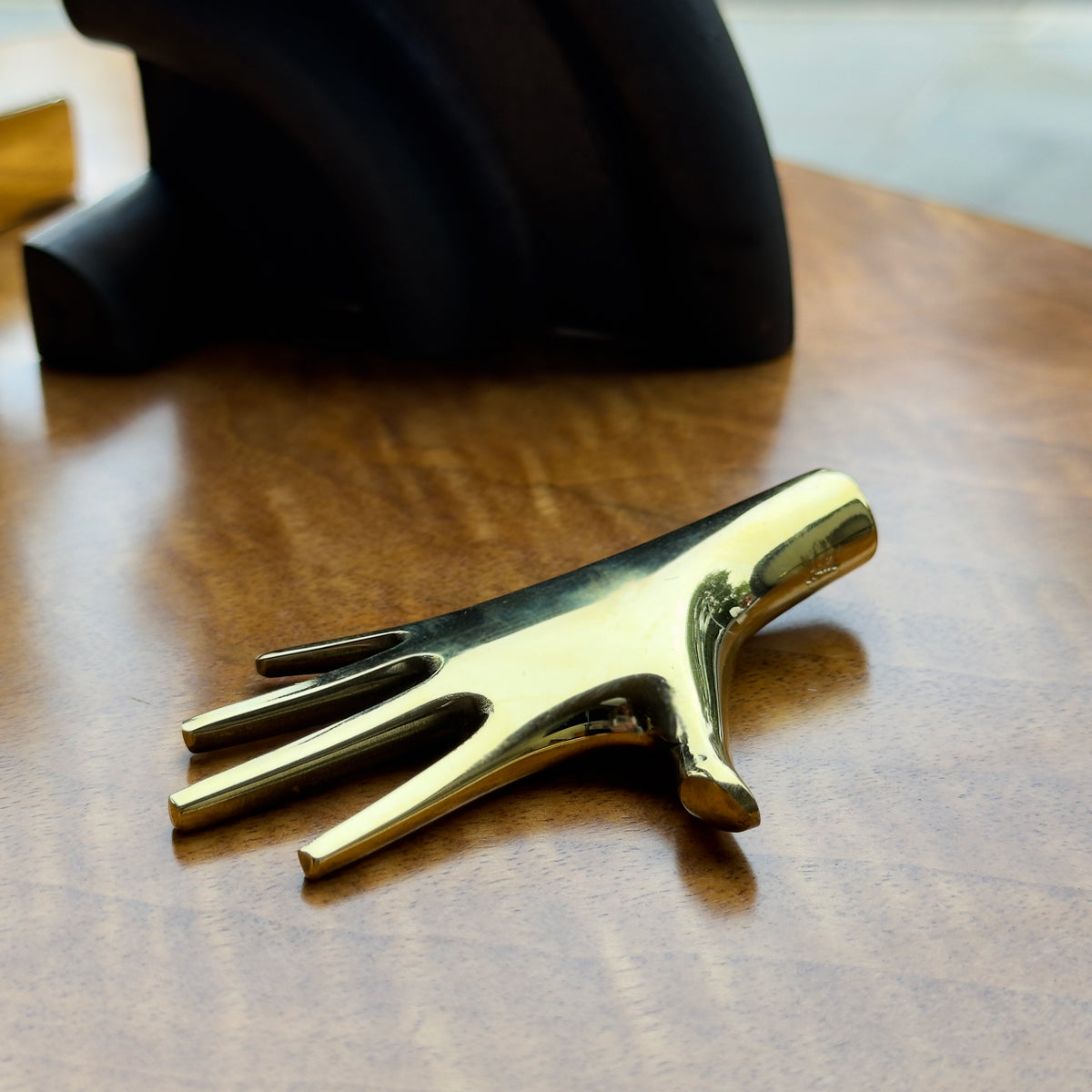 A hand-shaped paperweight designed by Carl Auböck II, made of cast brass in Vienna. This modernist piece showcases the distinctive craftsmanship and playful design typical of Auböck's work.