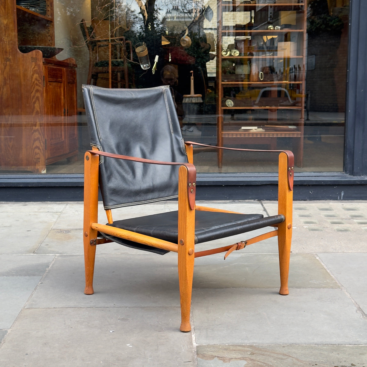 A Kaare Klint black leather safari chair, originally designed in the 1930s with this example produced in the 1950s. This original vintage piece, available at Sigmar, reflects Klint's pioneering approach to functional yet elegant Danish modern design
