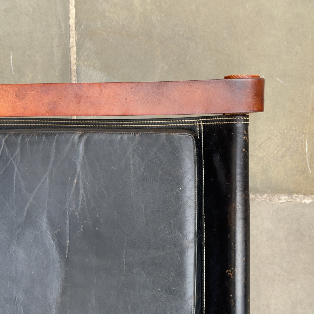 A Kaare Klint black leather safari chair, originally designed in the 1930s with this example produced in the 1950s. This original vintage piece, available at Sigmar, reflects Klint's pioneering approach to functional yet elegant Danish modern design