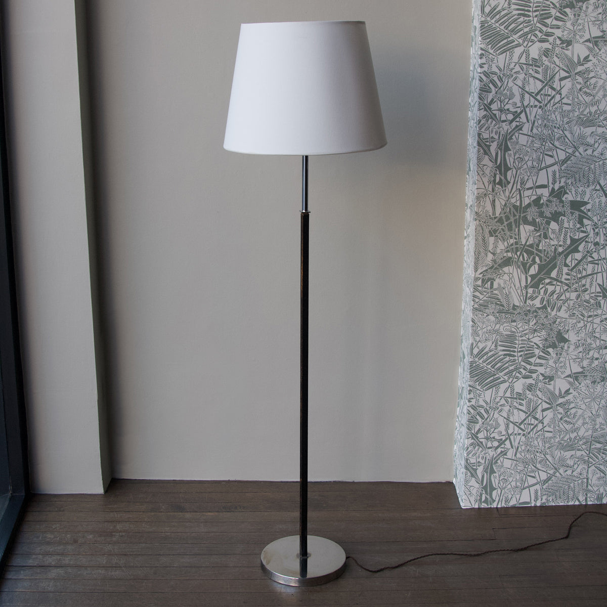 A vintage 1960s full-length floor lamp by Philips Netherlands, featuring a sleek steel frame complemented by leather accents. This mid-century modern design combines industrial materials with refined craftsmanship, offering both style and functionality.