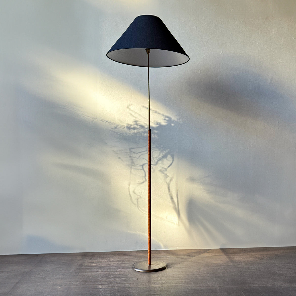 An original vintage leather-bound brass telescopic floor lamp from Denmark. This mid-century piece features an adjustable design with a rich patina, available from Sigmar London."