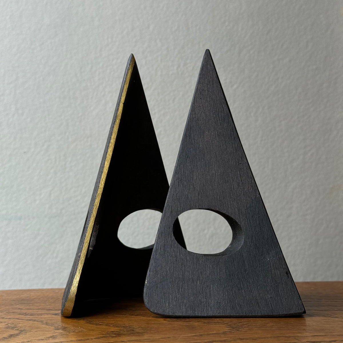 A solid cast brass bookend named 'Mask,' model 4100, designed by Carl Auböck. Based on a 1950s design, this piece is a sleek home accessory emblematic of modernist design.