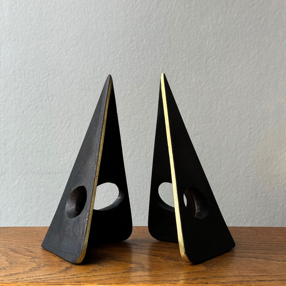 A solid cast brass bookend named 'Mask,' model 4100, designed by Carl Auböck. Based on a 1950s design, this piece is a sleek home accessory emblematic of modernist design.