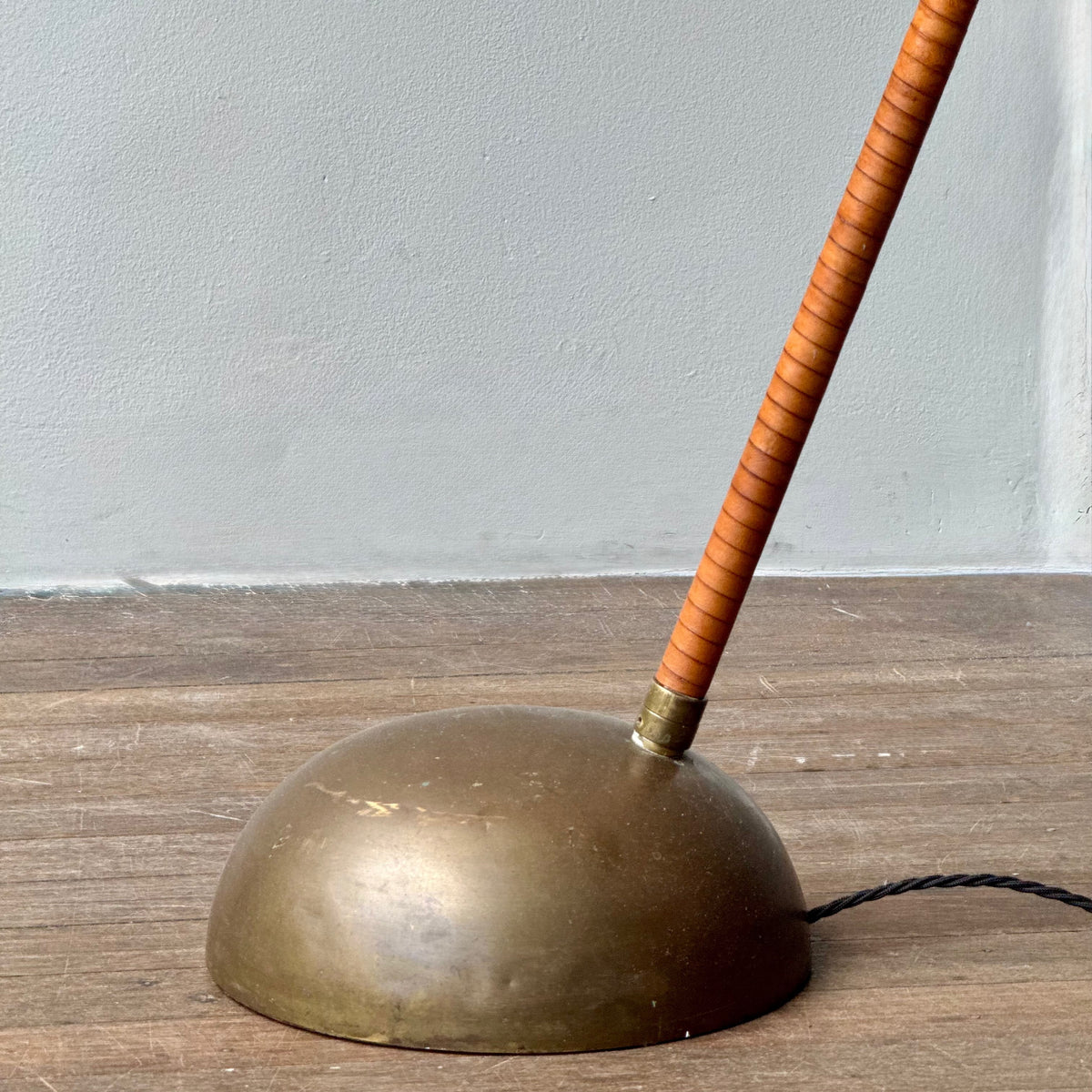 A leather bound arched floor lamp with weighted brass base and its original, custom sun-ray lampshade, recently restored with an ivory stretch silk.