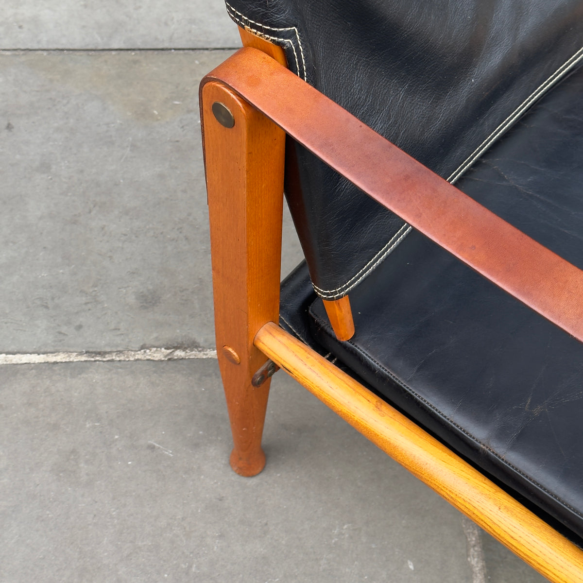 A Kaare Klint black leather safari chair, originally designed in the 1930s with this example produced in the 1950s. This original vintage piece, available at Sigmar, reflects Klint's pioneering approach to functional yet elegant Danish modern design