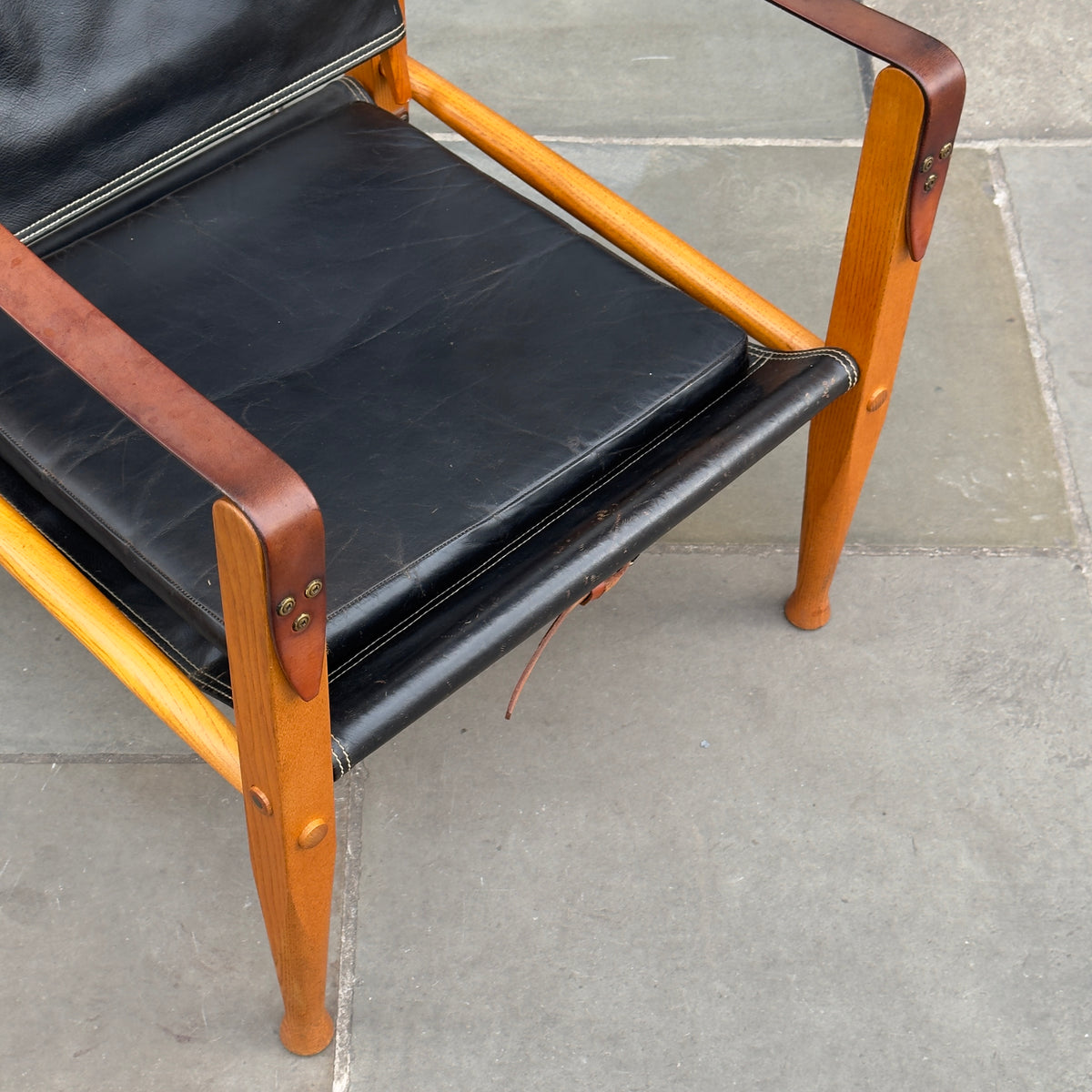 A Kaare Klint black leather safari chair, originally designed in the 1930s with this example produced in the 1950s. This original vintage piece, available at Sigmar, reflects Klint's pioneering approach to functional yet elegant Danish modern design