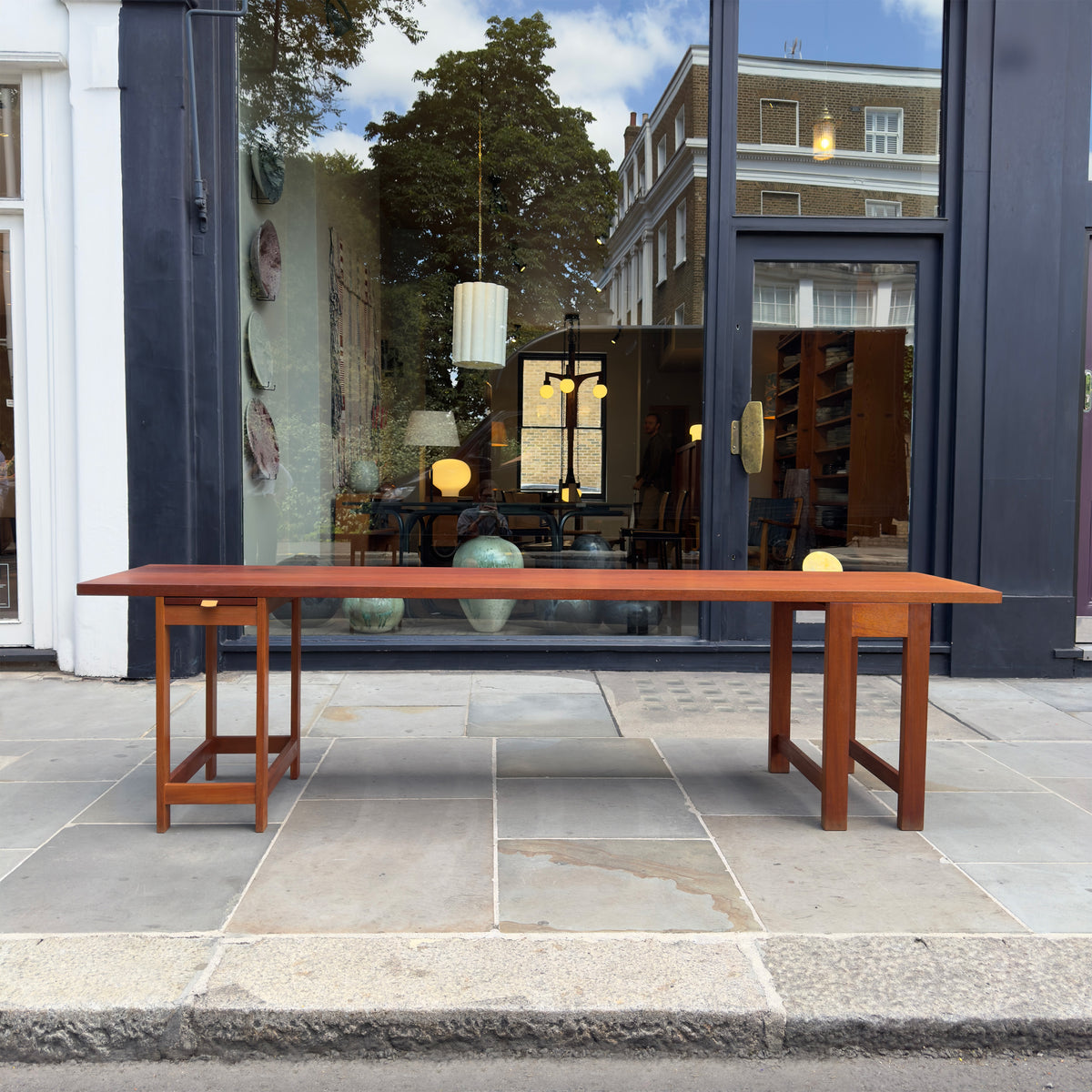 A long, narrow table designed by Sigurd Højland Olsen, made of mahogany and featuring a pull-out drawer. This piece showcases functional elegance and classic craftsmanship.