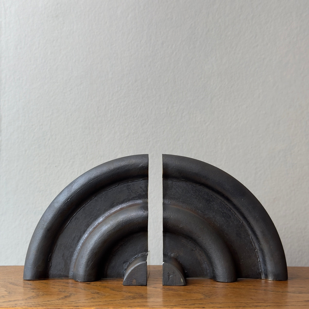 A cast brass bookend named 'Sun,' model 5533, designed by Carl Auböck and made in Vienna. This piece exemplifies modernist design with its sleek and artistic form.