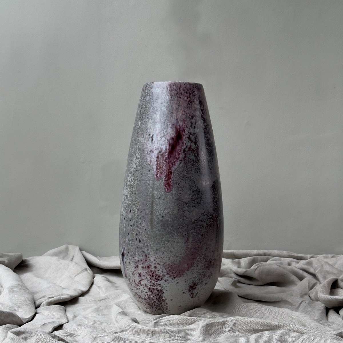 A very large, tall vase, handmade in Denmark by K H Würtz, featuring a vibrant combination of purple and red glaze.