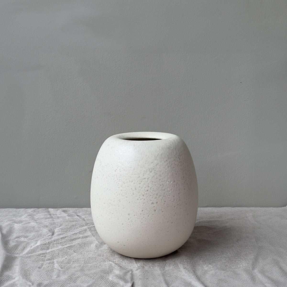 A handmade stoneware art piece ovoid vase, featuring a white matte glaze, crafted in Denmark. This elegant vessel combines simplicity and sophistication, showcasing the artistry and craftsmanship of the Danish ceramic studio. 