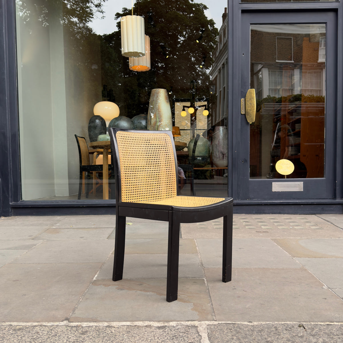 A  Bankstuhl chair designed by Willy Guhl, featuring a sleek combination of black lacquered frames and cane seating. These chairs exemplify Guhl's innovative approach to design, blending elegant, modern aesthetics with functional comfort.
