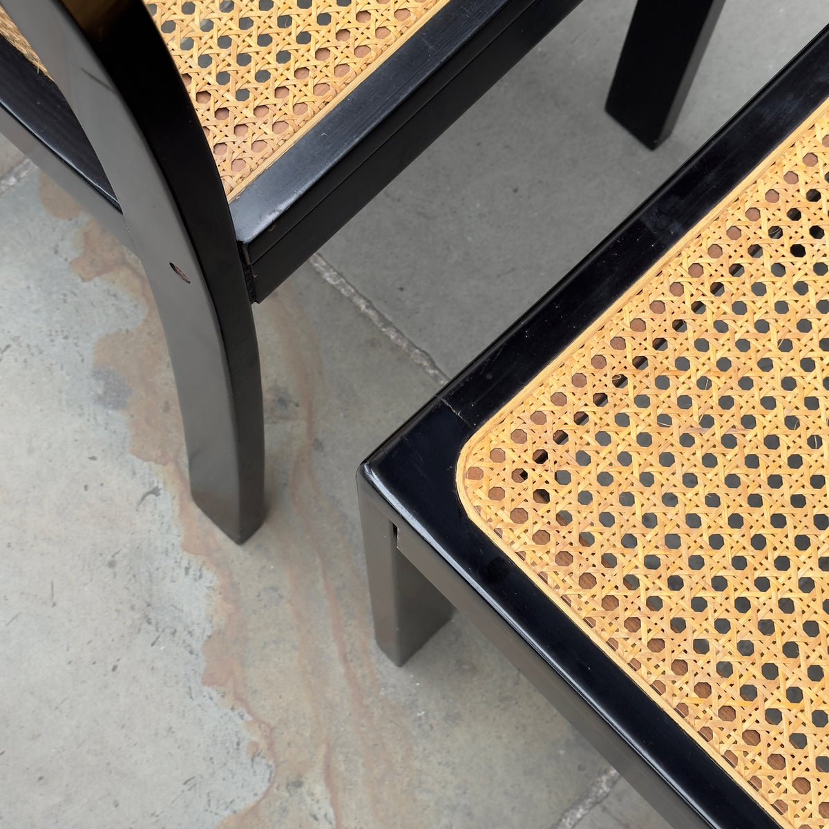 Seat detail of a Bankstuhl chair designed by Willy Guhl, featuring a sleek combination of black lacquered frames and cane seating. These chairs exemplify Guhl's innovative approach to design, blending elegant, modern aesthetics with functional comfort.