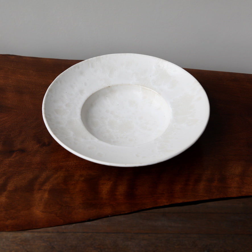 Large flat-out bowl by Kasper Würtz, featuring an ivory ‘Shape 11’ glaze. Handcrafted with Würtz’s signature Nordic craftsmanship, this elegant ceramic piece showcases a soft, refined design. Available at Sigmar London.