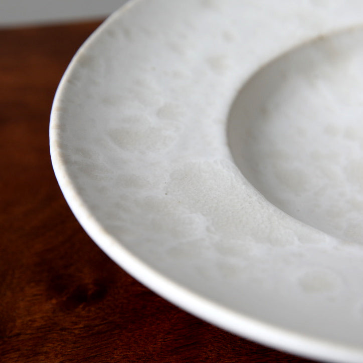 Large flat-out bowl by Kasper Würtz, featuring an ivory ‘Shape 11’ glaze. Handcrafted with Würtz’s signature Nordic craftsmanship, this elegant ceramic piece showcases a soft, refined design. Available at Sigmar London.