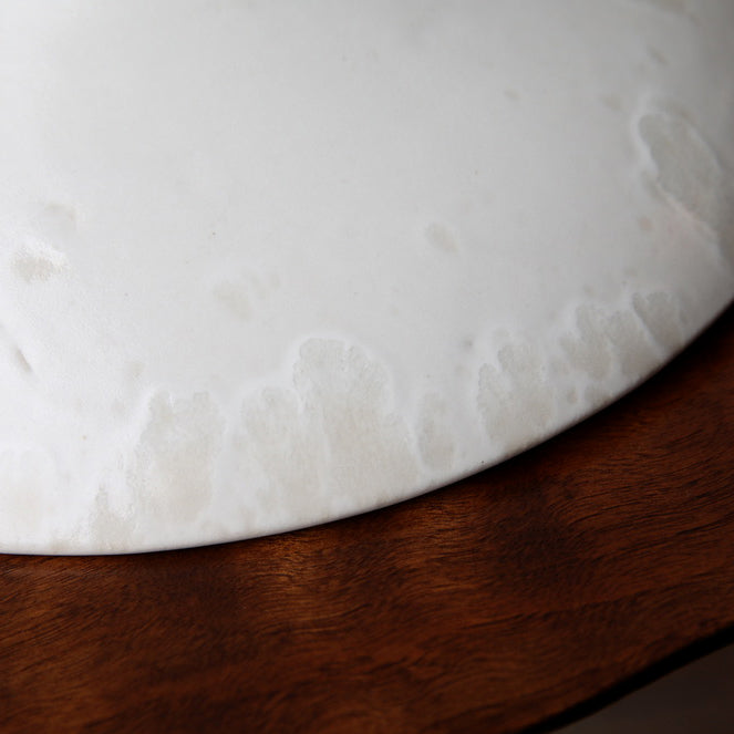 Large flat-out bowl by Kasper Würtz, featuring an ivory ‘Shape 11’ glaze. Handcrafted with Würtz’s signature Nordic craftsmanship, this elegant ceramic piece showcases a soft, refined design. Available at Sigmar London.