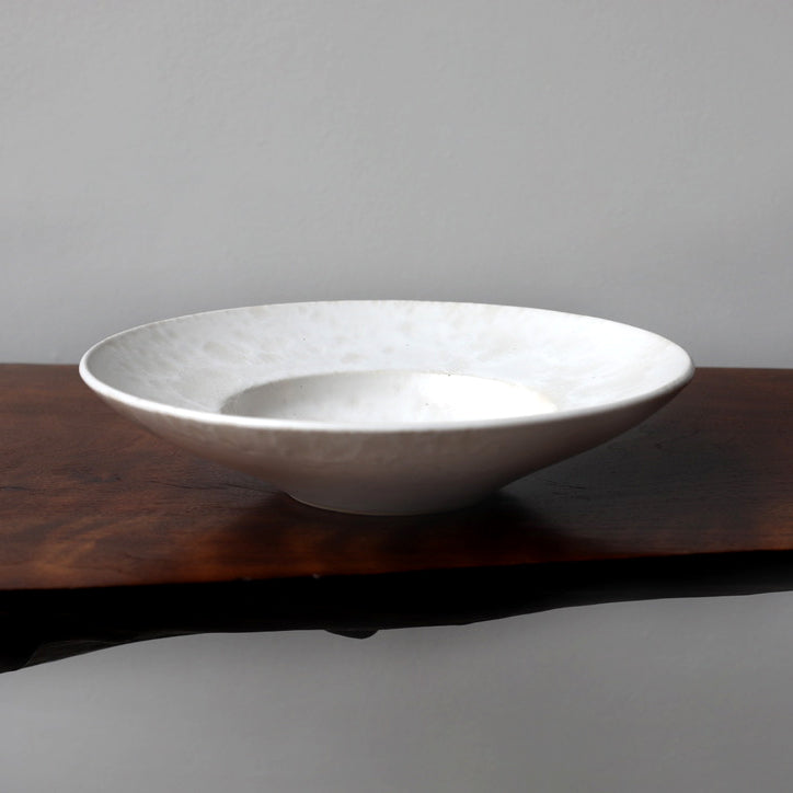 Large flat-out bowl by Kasper Würtz, featuring an ivory ‘Shape 11’ glaze. Handcrafted with Würtz’s signature Nordic craftsmanship, this elegant ceramic piece showcases a soft, refined design. Available at Sigmar London.