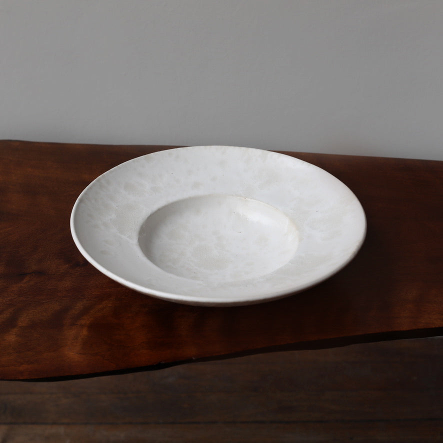 Large flat-out bowl by Kasper Würtz, featuring an ivory ‘Shape 11’ glaze. Handcrafted with Würtz’s signature Nordic craftsmanship, this elegant ceramic piece showcases a soft, refined design. Available at Sigmar London.