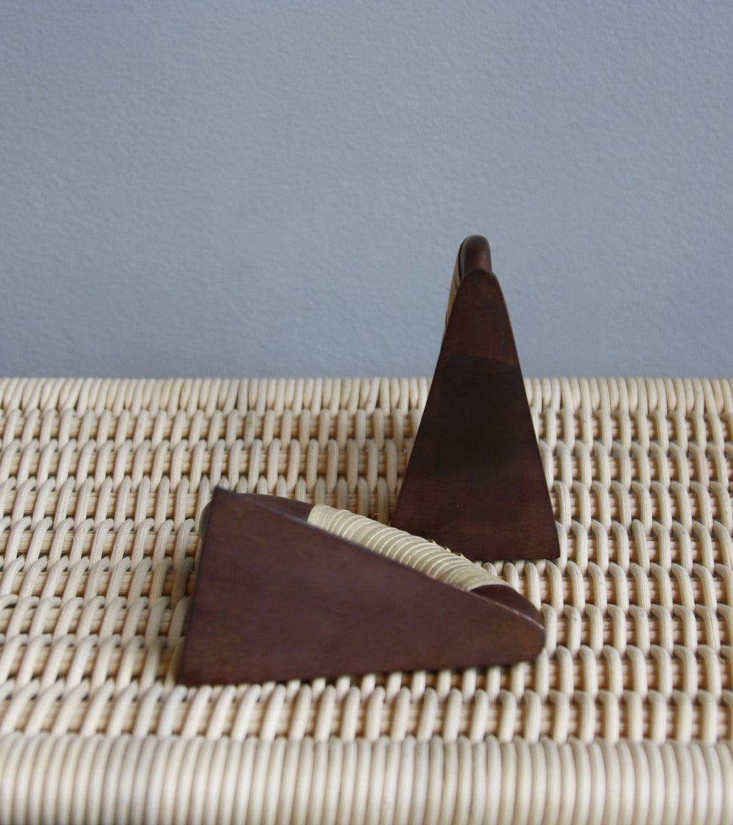 A pair of patinated flat iron bookends by Carl Auböck, crafted in the Werkstätte Auböck workshop, Vienna, Austria. Featuring blonde cane accents, these mid-century modernist pieces exemplify exceptional Austrian design and craftsmanship.