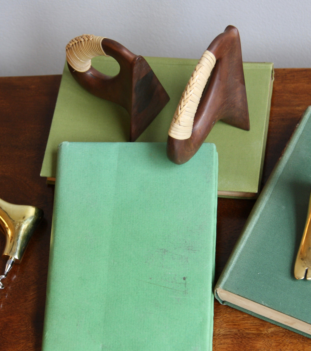 A pair of patinated flat iron bookends by Carl Auböck, crafted in the Werkstätte Auböck workshop, Vienna, Austria. Featuring blonde cane accents, these mid-century modernist pieces exemplify exceptional Austrian design and craftsmanship.