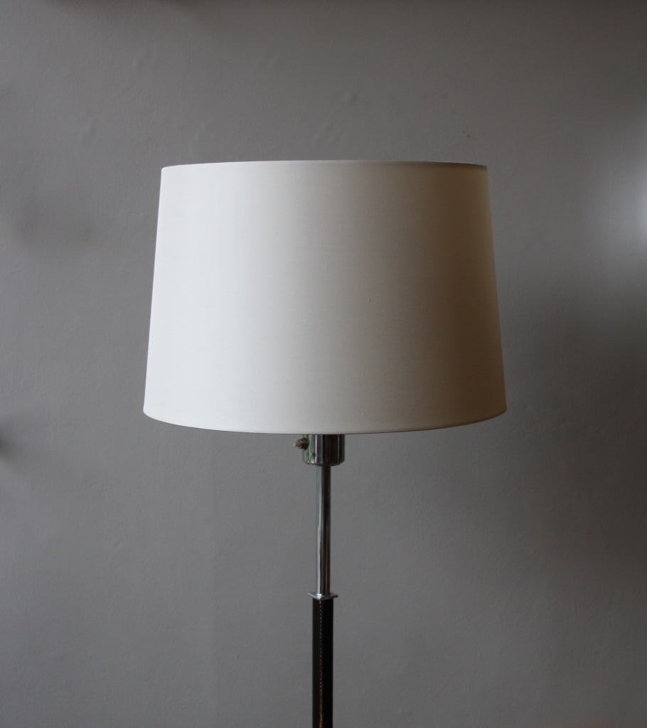 A vintage 1960s full-length floor lamp by Philips Netherlands, featuring a sleek steel frame complemented by leather accents. This mid-century modern design combines industrial materials with refined craftsmanship, offering both style and functionality.